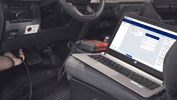 Interior veículo Ford Pro com laptop mostrando interface sistema de integração.